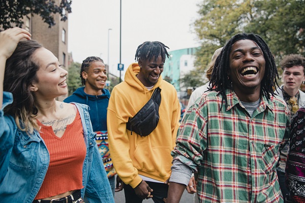 A group of people talking and laughing while walking.