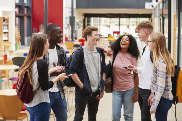 Student Group Socializing In Communal Area Of College